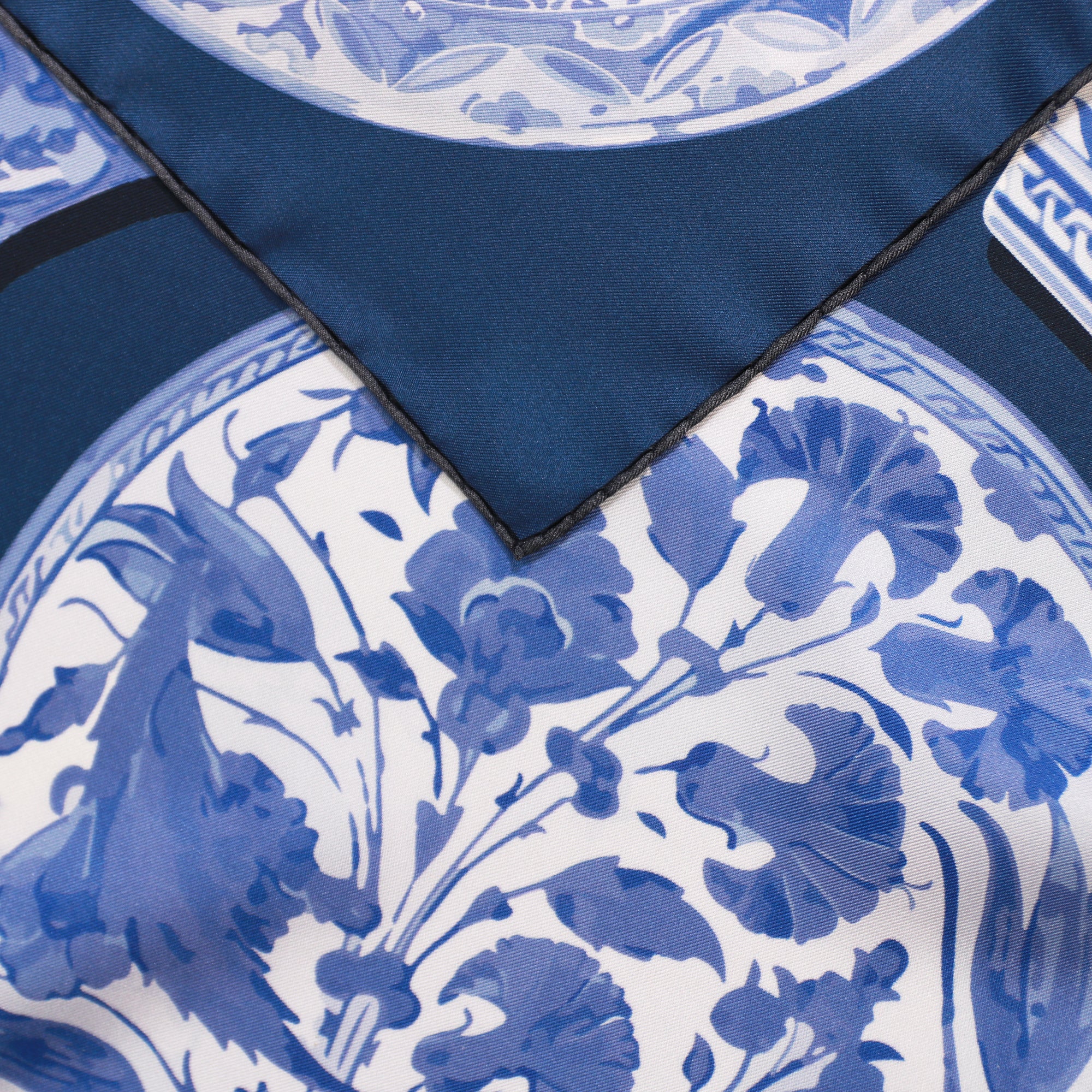 Detail of the Iznik Marian double-sided silk scarf showing hand-painted Iznik ceramic motifs and the hand-rolled hem on 100% silk twill.