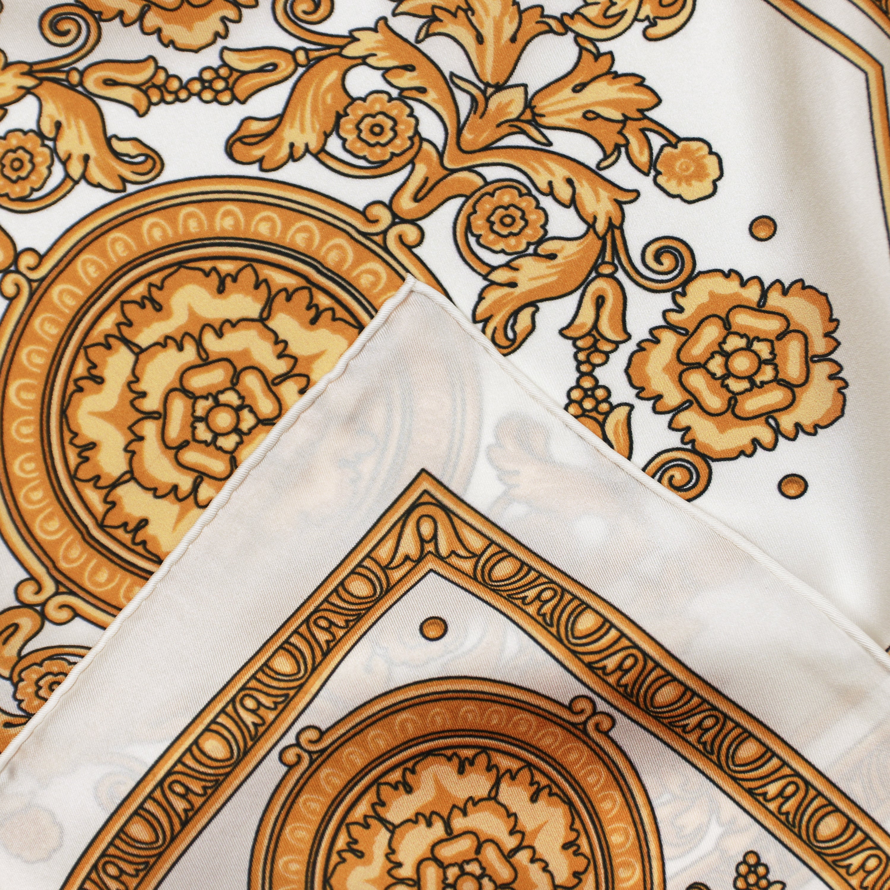 Detail of the Rococo Natural silk scarf showing ornamental rococo motifs and the hand-rolled hem.
