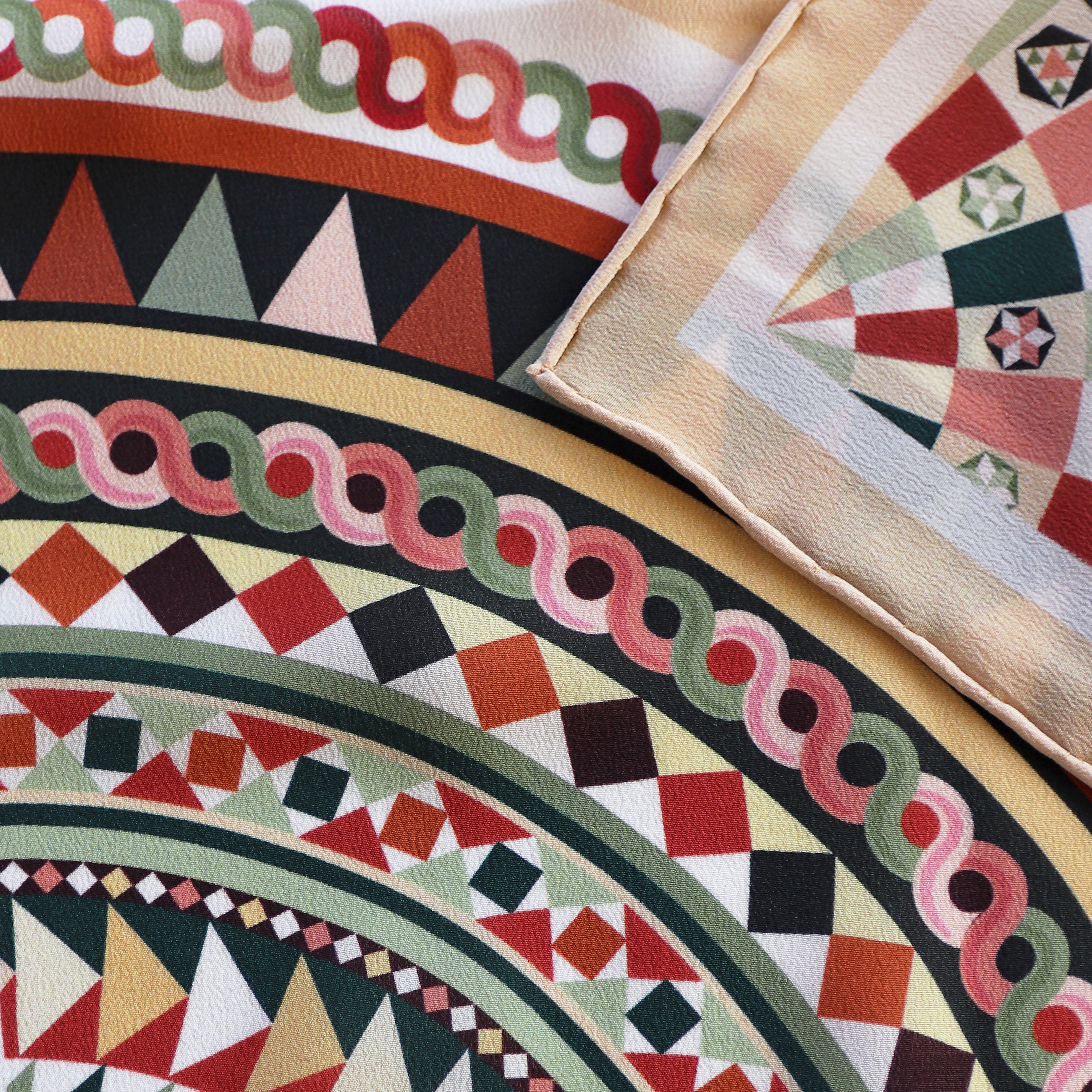 Detail of the Basilica Rena silk scarf showing geometric and architectural motifs and the hand-rolled hem.