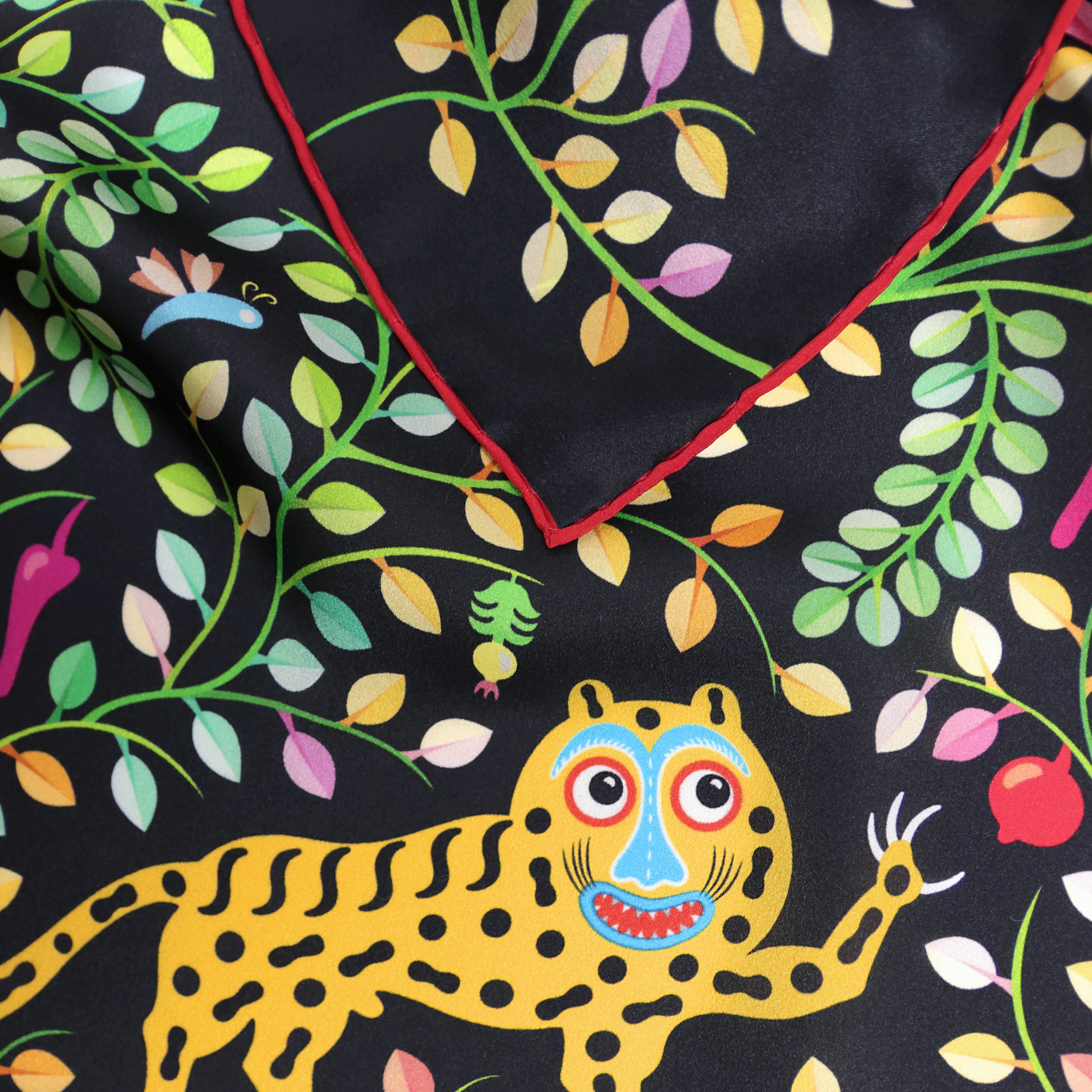Detail of the Kings of Dahomey Original silk scarf showing hand-painted animal and ornamental motifs and the hand-rolled hem.