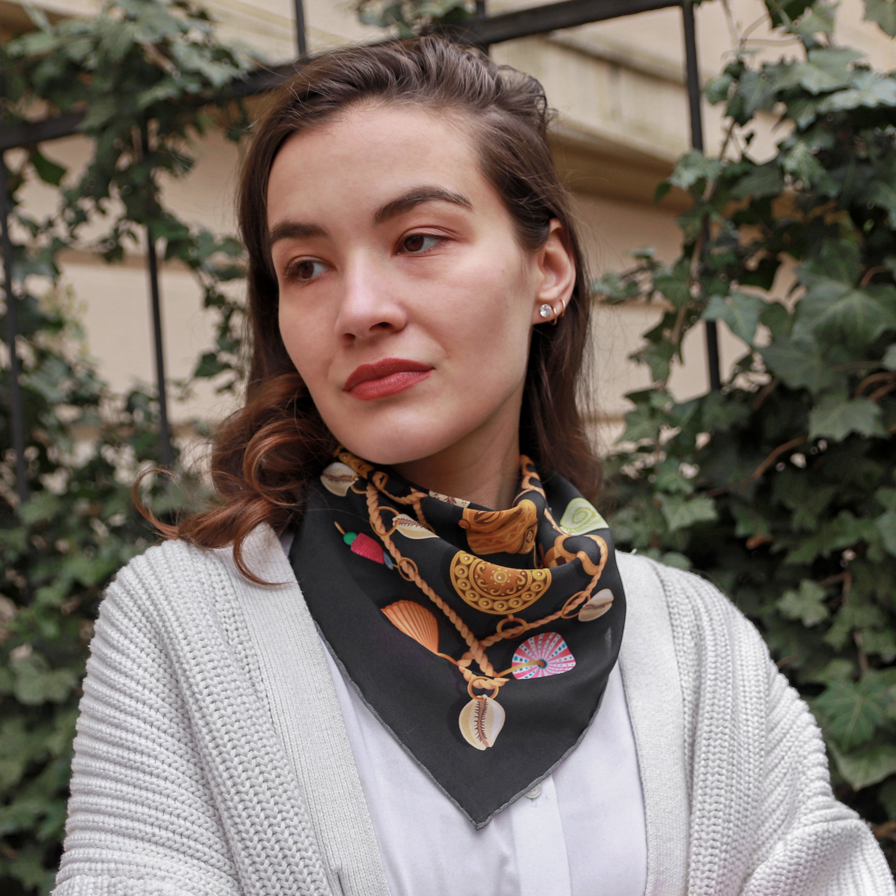Model wearing the Kauri Chloe silk bandana scarf styled around the neck with a white blouse.