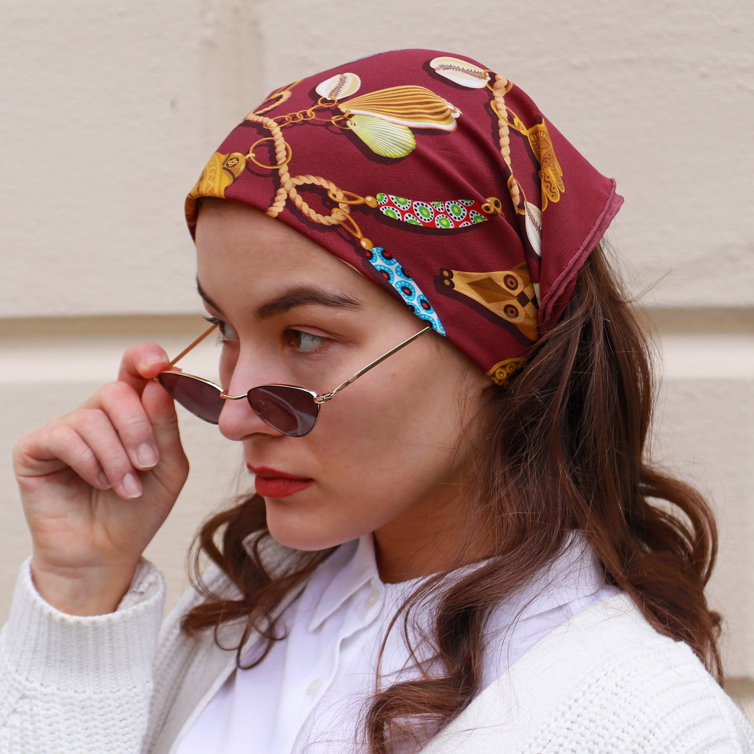 Model wearing the Kauri Rubis silk bandana scarf styled as a headscarf.
