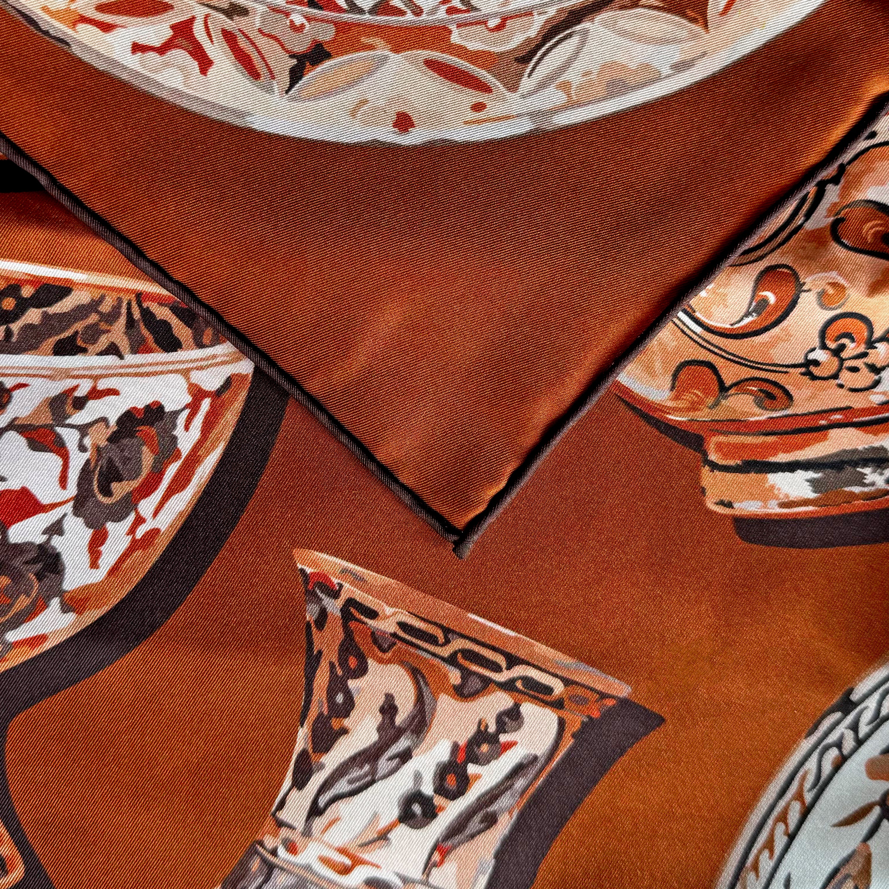 Detail of the Iznik Chamoise double-sided silk scarf showing hand-painted Iznik ceramic motifs and the hand-rolled hem on 100% silk twill.