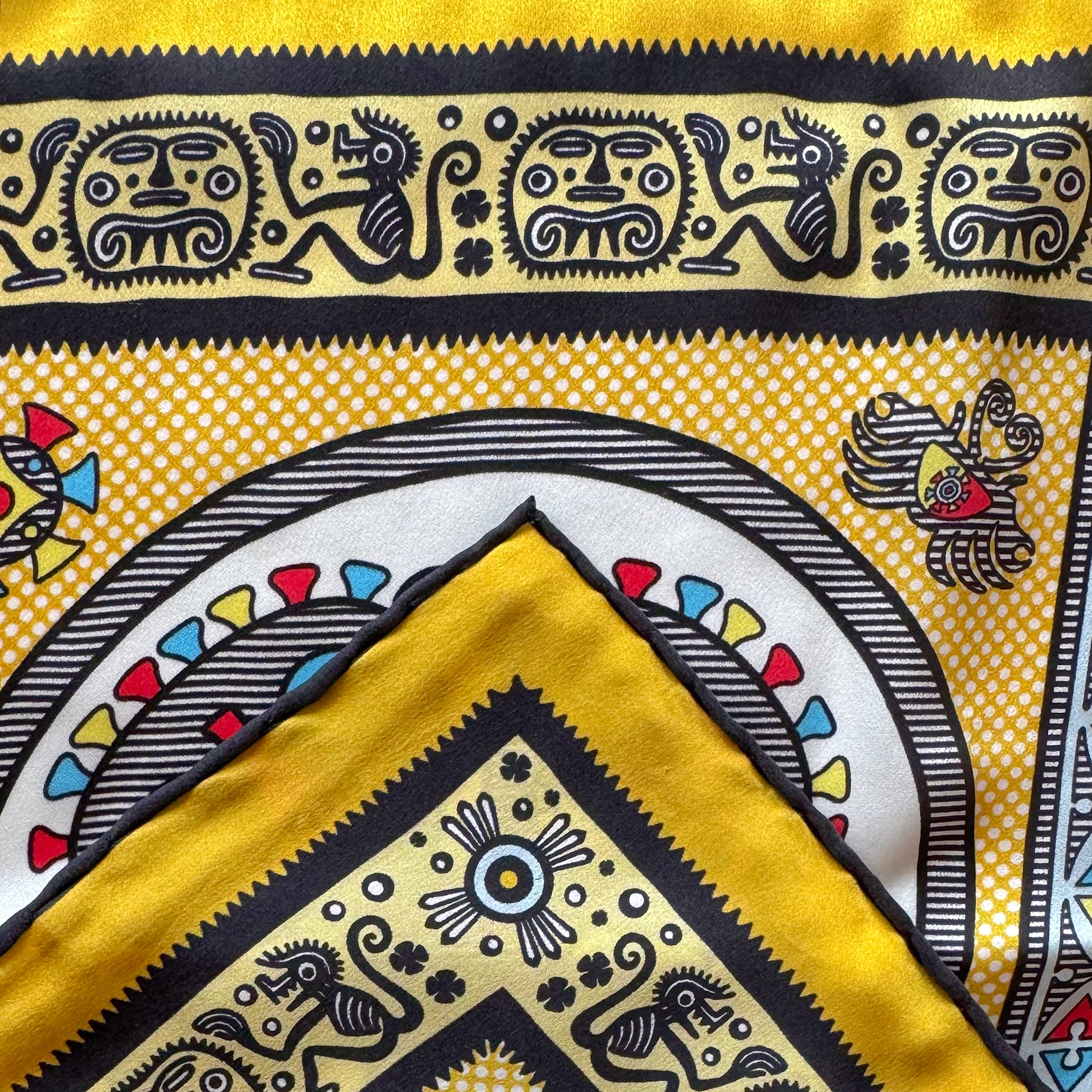 Detail of the Gran Coclé Royal silk scarf showing geometric and ritual-inspired motifs and the hand-rolled hem.