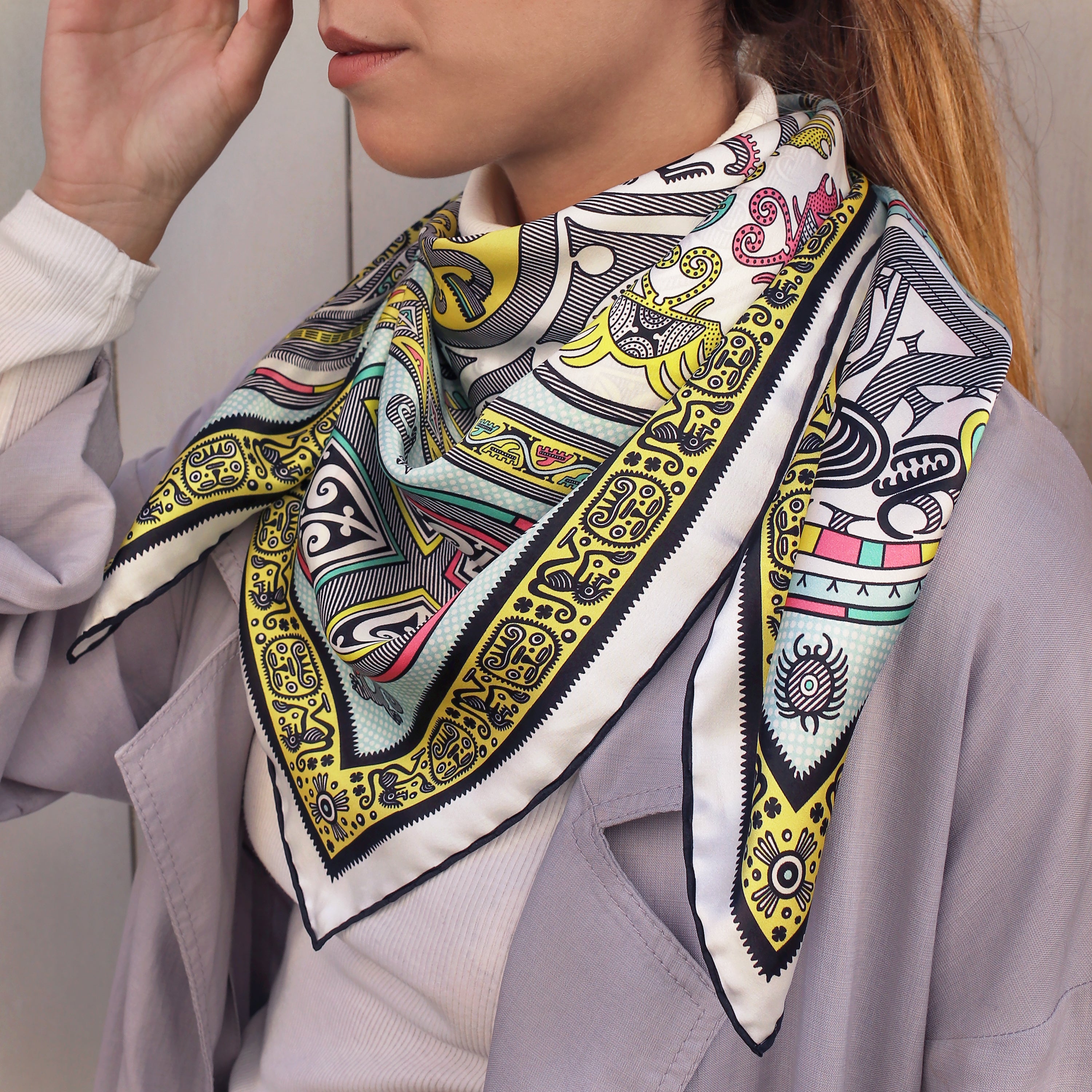 Model wearing the Gran Coclé Opal silk scarf styled around the neck with a light blouse.